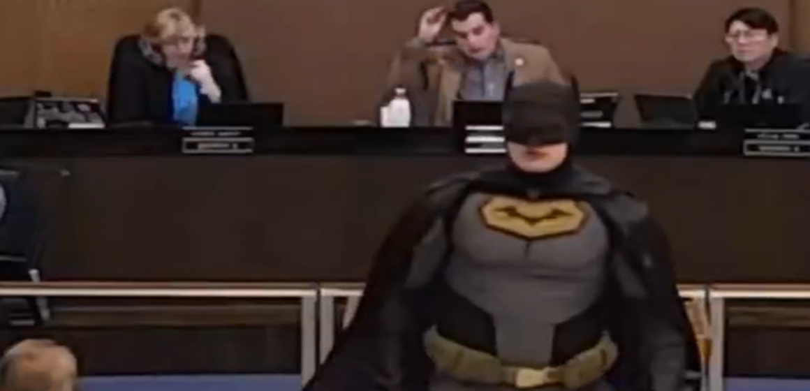 Captura de tela 2026-01-30 130143 Ativista vestido de Batman protesta contra serviço de imigração em reunião oficial nos EUA